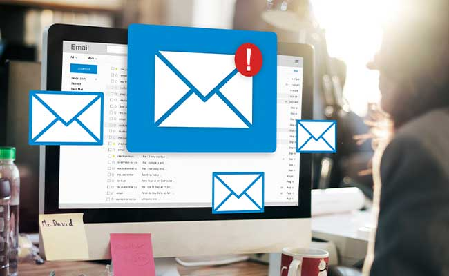 Computerbildschirm mit mehreren darüber eingeblendeten grafischen Briefumschlag-Symbolen eines mit rotem Ausrufezeichen.