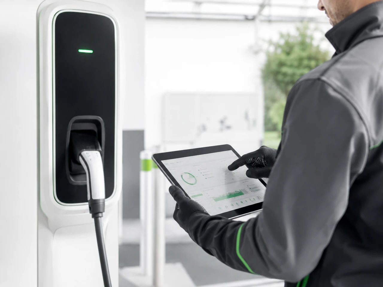 Techniker prüft eine Ladestation mit digitaler Wartungssoftware