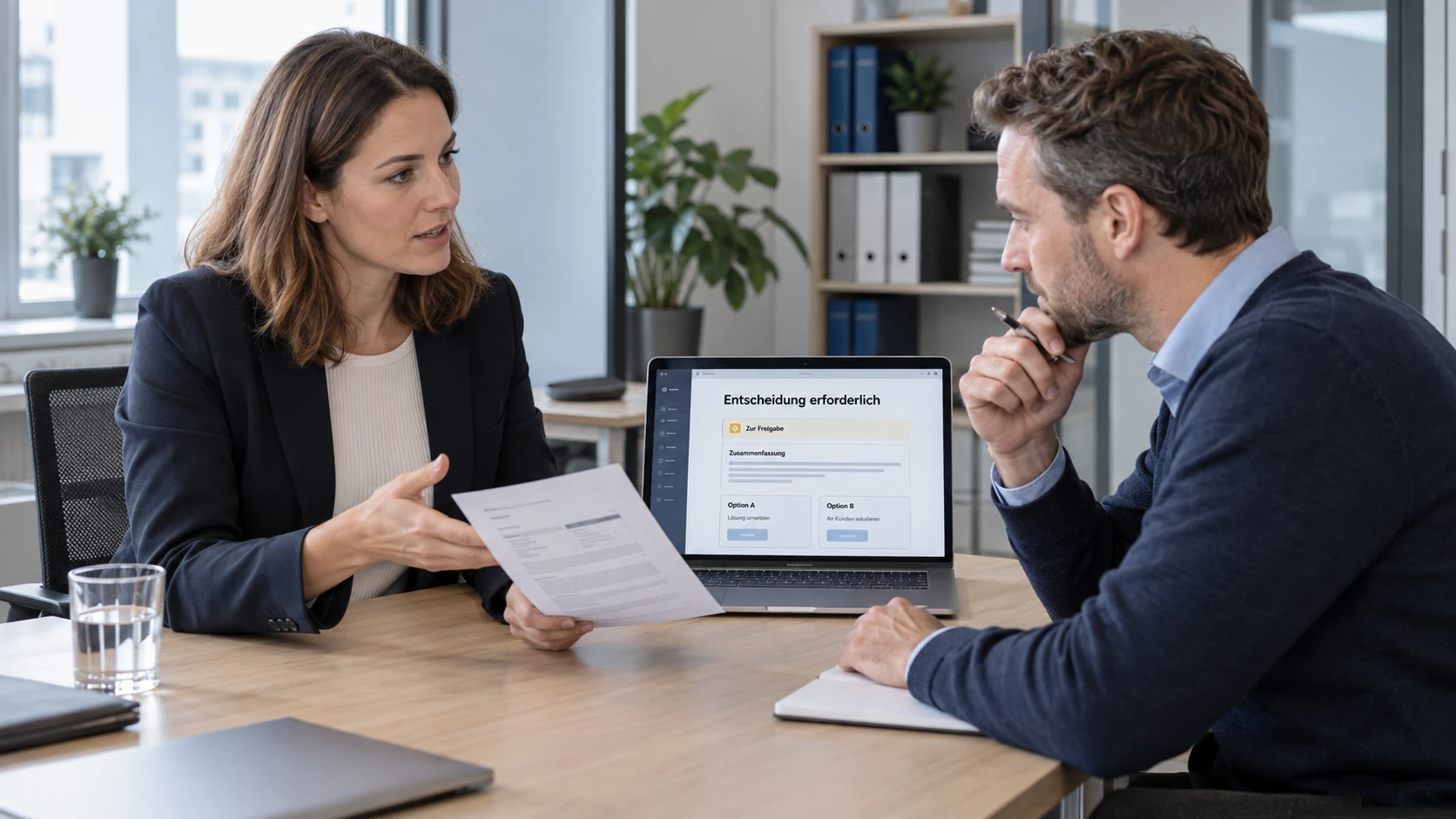 Zwei Personen besprechen einen Kundenfall, den der First-Level-Support-Agent zur Entscheidung vorgelegt hat